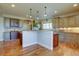 Open-concept kitchen featuring a center island with granite countertops and custom cabinetry at 14993 W 55Th Dr, Golden, CO 80403