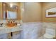 Elegant powder room featuring tile walls, an eye-catching mirror, and a unique sink at 14993 W 55Th Dr, Golden, CO 80403