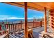 Inviting balcony with wood pillars features comfortable outdoor seating with scenic views of the surrounding mountains and forest at 11450 Marks Dr, Conifer, CO 80433