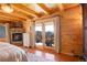 Bright bedroom features hardwood floors, a stone fireplace, and glass doors leading to a balcony with mountain views at 11450 Marks Dr, Conifer, CO 80433
