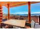 Deck with beautiful mountain view, wooden table and chairs for enjoying outdoor dining at 11450 Marks Dr, Conifer, CO 80433
