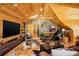 Spacious living room with wood floors and vaulted ceilings features a large TV and stylish decor at 11450 Marks Dr, Conifer, CO 80433