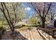 Landscaped backyard offers a tranquil retreat with a stone pathway, mature trees, and a cozy pergola seating area with open views at 5941 S Waco St, Aurora, CO 80016