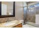 Neutral toned bathroom features granite counters, framed mirror, and a glass enclosed shower-tub combo at 5941 S Waco St, Aurora, CO 80016