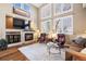 Bright living room features a fireplace, hardwood floors, soaring ceilings, and large windows with lots of natural light at 5941 S Waco St, Aurora, CO 80016