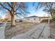 Charming single-story home featuring mature trees, a covered carport and a front lawn at 1050 Uvalda St, Aurora, CO 80011