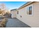 Home exterior featuring beige siding, brick patio, and direct access via the side door at 1050 Uvalda St, Aurora, CO 80011