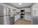 This kitchen boasts stainless steel appliances, bright white cabinets, and light granite countertops at 1050 Uvalda St, Aurora, CO 80011
