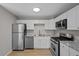 Modern kitchen features stainless steel appliances, granite counters, and white cabinets at 1050 Uvalda St, Aurora, CO 80011