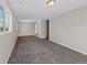 Spacious living room featuring neutral gray walls, modern carpeting, and ample natural light at 1050 Uvalda St, Aurora, CO 80011