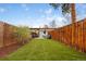 Well-maintained backyard features a lush lawn, wood fencing, and cozy seating, creating a private outdoor space at 3034 N High St, Denver, CO 80205