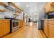 Modern kitchen with stainless steel appliances, open shelving, and hardwood flooring throughout at 3034 N High St, Denver, CO 80205