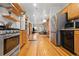 Open kitchen layout with stainless steel appliances and wood cabinets at 3034 N High St, Denver, CO 80205