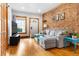 Inviting living room featuring hardwood floors, exposed brick wall, and comfortable seating at 3034 N High St, Denver, CO 80205