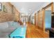 Bright living room boasts exposed brick, hardwood floors, and seamless flow to the kitchen at 3034 N High St, Denver, CO 80205