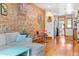 Bright living room with exposed brick, hardwood floors, and seamless flow to the kitchen at 3034 N High St, Denver, CO 80205