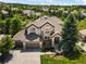 An attractive two-story home featuring a three-car garage, tile roof, and beautiful landscaping at 10057 S Shadow Hill Dr, Lone Tree, CO 80124