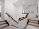 Upstairs hallway landing with carpeted steps and wood railing at 10057 S Shadow Hill Dr, Lone Tree, CO 80124