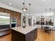 Bright kitchen features wood cabinets, island with seating, and pendant lighting adjacent to dining area at 10057 S Shadow Hill Dr, Lone Tree, CO 80124