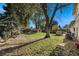 A spacious backyard featuring green grass, mature trees, and a wooden privacy fence at 3164 S Nucla St, Aurora, CO 80013