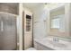 Classic bathroom featuring a tiled walk-in shower, single vanity sink, and white cabinets at 3164 S Nucla St, Aurora, CO 80013