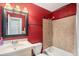 Bathroom featuring a tub-shower combination, white vanity, and a vibrant red painted wall at 3164 S Nucla St, Aurora, CO 80013