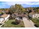 Aerial view of a charming single-Gathering home with well-maintained lawn, mature trees, and a cozy front porch at 3164 S Nucla St, Aurora, CO 80013