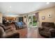 Open-concept living room with hardwood floors, stone fireplace, and sliding glass doors with view of back yard at 3164 S Nucla St, Aurora, CO 80013