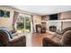 Cozy living room features a stone fireplace, hardwood floors, and sliding doors to the backyard at 3164 S Nucla St, Aurora, CO 80013