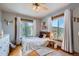 Bedroom with neutral tones, wooden accents, and abundant natural light from large windows at 11932 Coal Creek Heights Dr, Golden, CO 80403