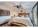 Comfortable bedroom with natural light, ceiling fan, and a wood-framed bed with bench at 11932 Coal Creek Heights Dr, Golden, CO 80403