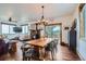 Open dining area with wood floors, rustic table, modern lighting, and access to an outdoor deck at 11932 Coal Creek Heights Dr, Golden, CO 80403