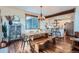 Open dining area featuring a rustic wood table and bench seating flowing into the modern kitchen at 11932 Coal Creek Heights Dr, Golden, CO 80403