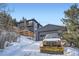 Exterior view of a mountain home and detached garage with a vehicle and snowplow parked outside at 11932 Coal Creek Heights Dr, Golden, CO 80403