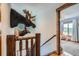 Hallway with wooden railing, large taxidermy animals, and a view into the bedroom at 11932 Coal Creek Heights Dr, Golden, CO 80403