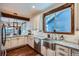 Bright kitchen with stainless steel appliances, granite countertops, subway tile, and a farmhouse sink at 11932 Coal Creek Heights Dr, Golden, CO 80403