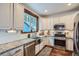 Modern kitchen with stainless steel appliances, granite counters, subway tile backsplash, and ample natural light at 11932 Coal Creek Heights Dr, Golden, CO 80403