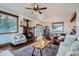 Open-concept living space featuring hardwood floors, stone fireplace, and large windows offering mountain views at 11932 Coal Creek Heights Dr, Golden, CO 80403