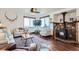 Cozy living room with hardwood floors, stone fireplace, large windows offering picturesque views, and stylish decor at 11932 Coal Creek Heights Dr, Golden, CO 80403