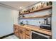 Close up of wet bar with wooden cabinets and shelving with recessed lighting at 11932 Coal Creek Heights Dr, Golden, CO 80403
