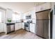 Modern kitchen with stainless steel appliances, white cabinets, and subway tile backsplash at 2714 N Federal Blvd, Denver, CO 80211
