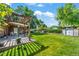 Expansive backyard featuring a covered patio, lush green lawn, and mature trees at 2069 E 116Th Ave, Northglenn, CO 80233