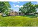 Expansive backyard with a lush lawn, covered patio, and mature shade trees at 2069 E 116Th Ave, Northglenn, CO 80233