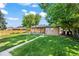 Lush backyard featuring a covered patio, well-maintained lawn, and mature trees at 2069 E 116Th Ave, Northglenn, CO 80233