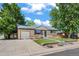 Single-story home with brick facade, attached garage, long driveway, and green front yard at 2069 E 116Th Ave, Northglenn, CO 80233