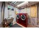 Functional laundry room with red front-loading washer and dryer, utility sink, and good lighting at 2069 E 116Th Ave, Northglenn, CO 80233
