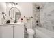 Updated bathroom with marble tile, a tub with a shower and sleek black fixtures at 16623 E Kent Dr, Aurora, CO 80013