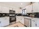 Bright kitchen with stainless steel appliances, marble backsplash and modern cabinetry at 16623 E Kent Dr, Aurora, CO 80013