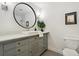 Elegant bathroom featuring a vessel sink, a large round mirror, and custom cabinetry at 11021 Otis St, Westminster, CO 80020