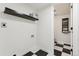 Practical laundry room boasting black and white tiled flooring and shelving at 11021 Otis St, Westminster, CO 80020